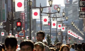 People walk under Japanese national flag